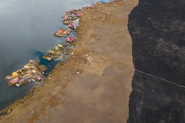 This aerial view shows a huge blackened area in the Lake Titicaca National Reserve near the floating islands of the Uros in Puno, Peru, on October 23, 2026, following a fire that ravaged around 400 hectares of totora reeds on October 21. Forest fires fueled by El Nino have killed 12 people and left hundreds homeless in Peru since June, authorities in the Andean country said on October 21. (Photo by URIEL MONTEFUR / AFP)