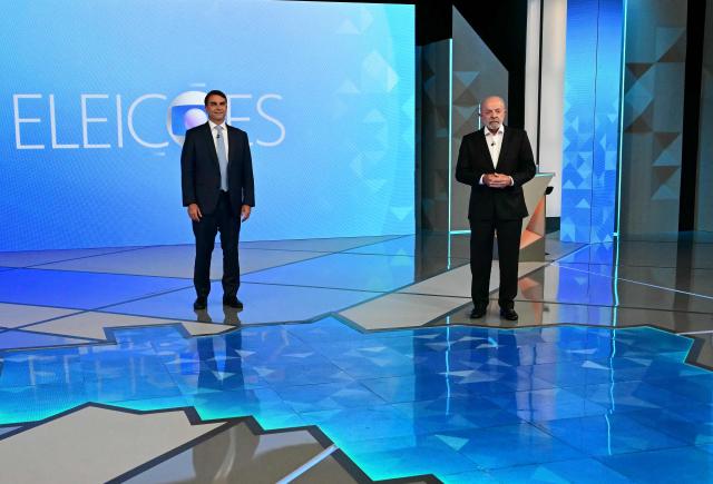 Brazil's right-wing presidential candidate Flavio Bolsonaro (L) and Brazil's President and presidential candidate Luiz Inacio Lula da Silva pose before a presidential debate ahead of the election runoff in Rio de Janeiro, Brazil, on October 23, 2026. (Photo by Pablo PORCIUNCULA / AFP)