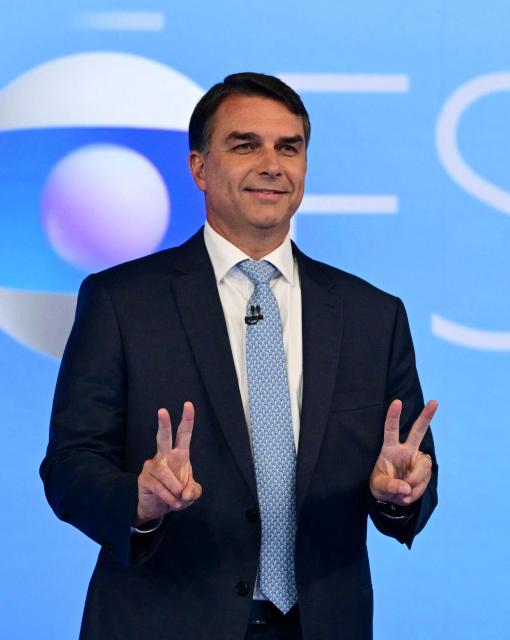 Brazil's right-wing presidential candidate Flavio Bolsonaro flashes the V sign during a presidential debate against incumbent President Luiz Inacio Lula da Silva ahead of the election runoff in Rio de Janeiro, Brazil, on October 23, 2026. (Photo by Pablo PORCIUNCULA / AFP)