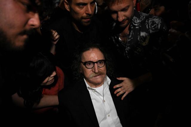 Argentina's music icon Charly Garcia greets fans outside his residence to celebrate his 75th birthday in Buenos Aires on October 23, 2026. (Photo by Luis ROBAYO / AFP)