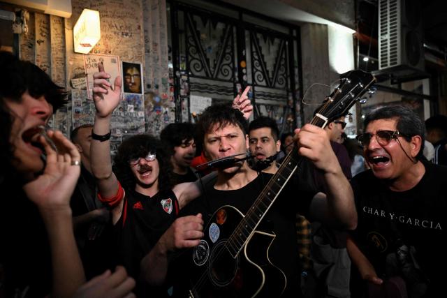 Fans of Argentina's music icon Charly Garcia plau music outside his residence to celebrate his 75th birthday in Buenos Aires on October 23, 2026. (Photo by Luis ROBAYO / AFP)