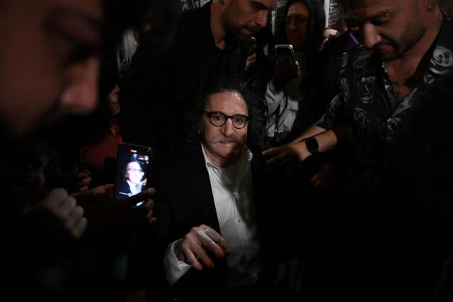 Argentina's music icon Charly Garcia greets fans outside his residence to celebrate his 75th birthday in Buenos Aires on October 23, 2026. (Photo by Luis ROBAYO / AFP)