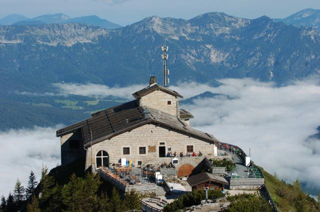 Picture taken on June 21, 2004 shows tourists sitting on the terrace of the mountain guesthouse Kehlsteinhaus, that was Adolf Hitler's mountain retreat, known as the Eagle's Nest, seated in the mountains over Berchtesgaden, in the southern German state of Bavaria. Emergency services arrived on site on late October 23, 2026 and found a large fire. German police said on October 24, 2026 they have detained a suspect following a fire at Adolf Hitler's mountain retreat, known as the Eagle's Nest. (Photo by Peter Kneffel / dpa / AFP) / Germany OUT