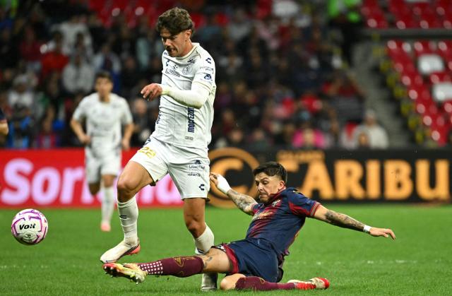 San Luis' Spain forward #22 Rafa Llorente and Atlante's Argentine defender #44 Aaron Quiros fight for the ball during the Liga MX Apertura tournament football match between Atlante and San Luis at the Banorte stadium in Mexico City on October 23, 2026. (Photo by Yuri CORTEZ / AFP)