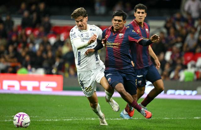 San Luis' Spain forward #22 Rafa Llorente and Atlante's defender #29 Walter Portales fight for the ball during the Liga MX Apertura tournament football match between Atlante and San Luis at the Banorte stadium in Mexico City on October 23, 2026. (Photo by Yuri CORTEZ / AFP)