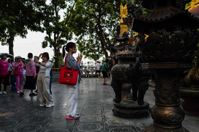 A woman prays at a temple in Hanoi on October 23, 2026. (Photo by ANTHONY WALLACE / AFP)