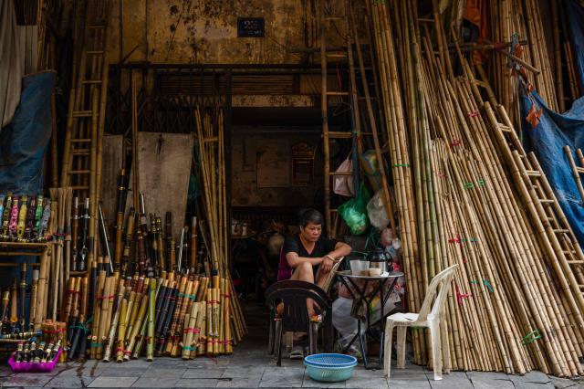 A vendor waits for customers outside her bamboo products shop in Hanoi on October 23, 2026. (Photo by ANTHONY WALLACE / AFP)