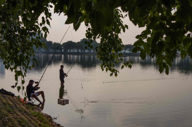 Anglers fish in Truc Bach Lake in Hanoi on October 23, 2026. (Photo by ANTHONY WALLACE / AFP)