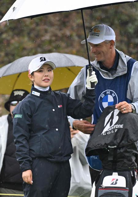 Yuri Yoshida of Japan stands under her umbrella with her caddie on the 6th tee during the third round of the LPGA Tour - BMW Ladies Championship golf tournament at Pine Beach Golf Links in Haenam on October 24, 2026. (Photo by Jung Yeon-je / AFP)