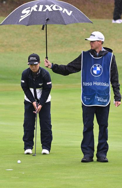 Nasa Hataoka of Japan lines up a putt as her caddie holds an umbrella on the 5th green during the third round of the LPGA Tour - BMW Ladies Championship golf tournament at Pine Beach Golf Links in Haenam on October 24, 2026. (Photo by Jung Yeon-je / AFP)