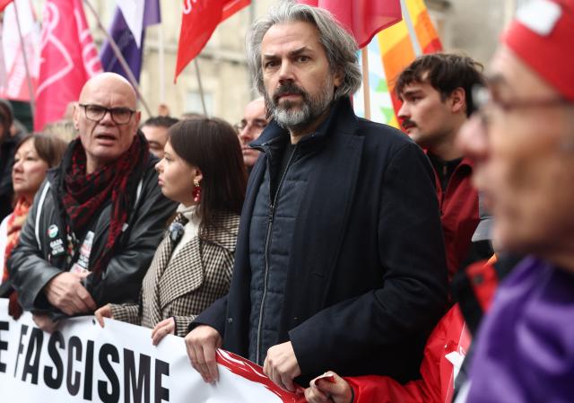 La France Insoumise - Nouveau Front Populaire's group MP Aymeric Caron (centre R) attends a demonstration "against racism, fascism and imperialism" on the sidelines of the Congress of the Far-right party Rassemblement National (RN) in Orleans, central France on October 24, 2026. Amid another Saturday of protests under tight security across France, Orleans is hosting the National congress of the Far-right party Rassemblement National and preparing for a record-breaking demonstration, on the eve of their first major campaign rally. (Photo by ROMAIN PERROCHEAU / AFP)
