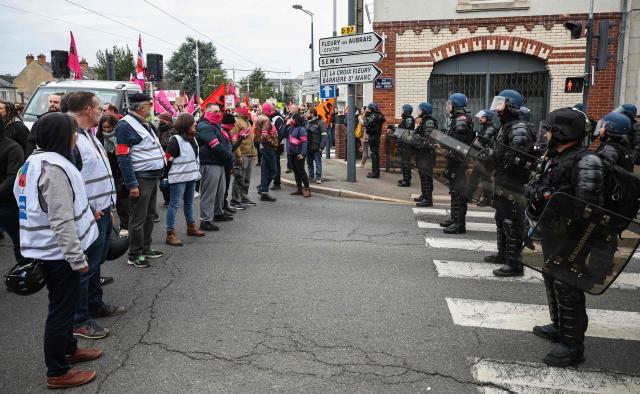 Protesters including some from FSU and Sud Solidaires unions (L) stand on a crackled road next face to French gendarmes during a demonstration "against racism, fascism and imperialism" on the sidelines of the Congress of the Far-right party Rassemblement National (RN) in Orleans, central France on October 24, 2026. Amid another Saturday of protests under tight security across France, Orleans is hosting the National congress of the Far-right party Rassemblement National and preparing for a record-breaking demonstration, on the eve of their first major campaign rally. (Photo by SIMON WOHLFAHRT / AFP)