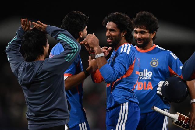 India's Tilak Varma (C) and Nitish Kumar Reddy (R) are congratulated by teammates after winning the second Twenty20 international cricket match between New Zealand and India at Hagley Oval in Christchurch on October 24, 2026. (Photo by Sanka VIDANAGAMA / AFP)