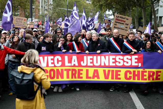 (From centre-L) French leftist party La France Insoumise (LFI) group MP Aurelie Trouve, French leftist party La France Insoumise (LFI) group MP Eric Coquerel, French leftist party La France Insoumise (LFI) candidate in France's 2027 Presidential election Jean-Luc Melenchon, French leftist party La France Insoumise (LFI) group MP Manuel Bompard, French leftist party La France Insoumise (LFI) group MP Paul Vannier and France's left-wing party La France Insoumise (LFI) member of European Parliament Manon Aubry carry a banner reading "With the Youth against the high cost of living" during a demonstration in favor of purchasing power, the protection of public services, and fiscal and social justice, in Paris on October 24, 2026 as part of a nationwide call for mobilisation bringing together former members of the Yellow Vest movement, labor unions, high school and university students. Protests by high school students over learning conditions sparked a movement that has since spread nationwide, fuelled by broader anger over the rising cost of living. About 70,000 security personnel will be deployed on October 24, 2026, Interior Minister said at a news conference, warning that calls for violence and looting were circulating on social media. (Photo by Sameer AL-DOUMY / AFP)