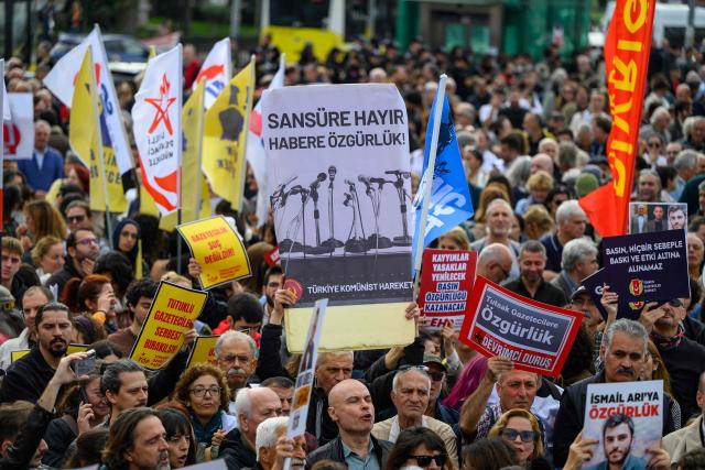 Protesters hold placards, one (C) reading "No to Censorship, Freedom for News'' during a rally against what they described as growing pressure on journalists including arrests and media shutdowns, in Istanbul, on October 24, 2026. (Photo by Yasin AKGUL / AFP)