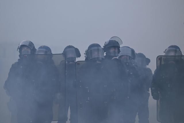 French gendarmes stand amidst tear gas during a demonstration in favor of purchasing power, the protection of public services, and fiscal and social justice, in Nantes, western France on October 24, 2026 as part of a nationwide call for mobilisation bringing together former members of the Yellow Vest movement, labor unions, high school and university students. Protests by high school students over learning conditions sparked a movement that has since spread nationwide, fuelled by broader anger over the rising cost of living. About 70,000 security personnel will be deployed on October 24, 2026, Interior Minister said at a news conference, warning that calls for violence and looting were circulating on social media. (Photo by Guillaume Saligot / AFP)