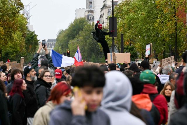A protester dressed as Spiderman rises his fist during a demonstration in favor of purchasing power, the protection of public services, and fiscal and social justice, in Paris on October 24, 2026 as part of a nationwide call for mobilisation bringing together former members of the Yellow Vest movement, labor unions, high school and university students. Protests by high school students over learning conditions sparked a movement that has since spread nationwide, fuelled by broader anger over the rising cost of living. About 70,000 security personnel will be deployed on October 24, 2026, Interior Minister said at a news conference, warning that calls for violence and looting were circulating on social media. (Photo by NICOLAS TUCAT / AFP)