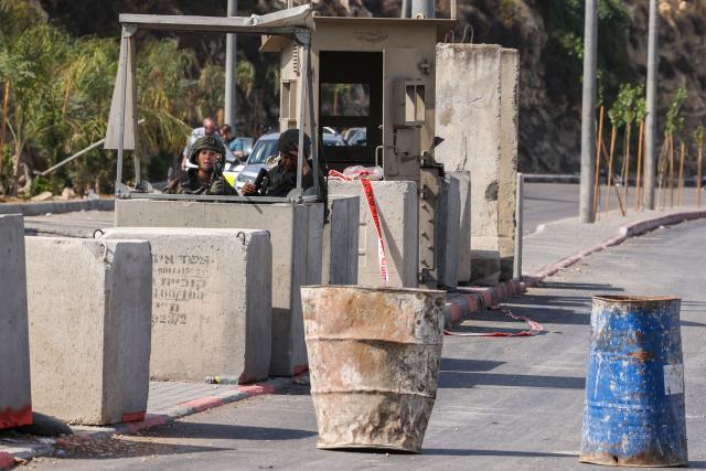 Israeli soldiers take position at the blocked northern checkpoint in Hebron, in the occupied West Bank, on October 24, 2026. Israeli forces pushed into the West Bank city of Hebron on October 24 and displaced some 250 families, some in the middle of the night, vowing a heavy price over a deadly attack on soldiers. (Photo by HAZEM BADER / AFP)