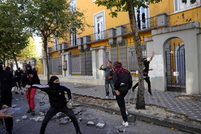 Protesters throw stones towards riot police during a national anti-government demonstration - called by the student-led protest movement to demand better support for education and prime minister's resignation, outside the Ministry of Education in central Tirana on October 24, 2026. (Photo by Adnan Beci / AFP)