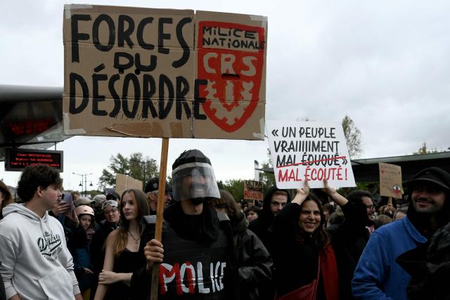 A protester holds a placard reading "Forces of disorder" (a play on words with security forces) during a demonstration in favor of purchasing power, the protection of public services, and fiscal and social justice, in Bordeaux, western France on October 24, 2026 as part of a nationwide call for mobilisation bringing together former members of the Yellow Vest movement, labor unions, high school and university students. Protests by high school students over learning conditions sparked a movement that has since spread nationwide, fuelled by broader anger over the rising cost of living. About 70,000 security personnel will be deployed on October 24, 2026, Interior Minister said at a news conference, warning that calls for violence and looting were circulating on social media. (Photo by Philippe LOPEZ / AFP)