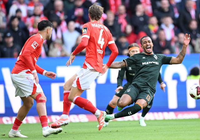 Mainz' German defender #04 Stefan Posch fouls Bremen's Brazilian defender #13 Arthur during the German first division Bundesliga football match between Mainz 05 and Werder Bremen in Mainz on October 24, 2026. (Photo by Kirill KUDRYAVTSEV / AFP) / DFL REGULATIONS PROHIBIT ANY USE OF PHOTOGRAPHS AS IMAGE SEQUENCES AND/OR QUASI-VIDEO