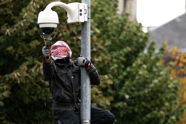 TOPSHOT - A protester breaks a surveillance camera during a demonstration in favor of purchasing power, the protection of public services, and fiscal and social justice, in Strasbourg, eastern France on October 24, 2026 as part of a nationwide call for mobilisation bringing together former members of the Yellow Vest movement, labor unions, high school and university students. Protests by high school students over learning conditions sparked a movement that has since spread nationwide, fuelled by broader anger over the rising cost of living. About 70,000 security personnel will be deployed on October 24, 2026, Interior Minister said at a news conference, warning that calls for violence and looting were circulating on social media. (Photo by ROMÉO BOETZLE / AFP)