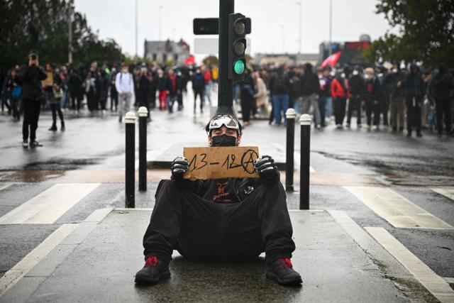 TOPSHOT - A protester holds a placard reading the code "1312" referring to the acronym ACAB "All Cops Are Bastards" during a demonstration in favor of purchasing power, the protection of public services, and fiscal and social justice, in Nantes, western France on October 24, 2026 as part of a nationwide call for mobilisation bringing together former members of the Yellow Vest movement, labor unions, high school and university students. Protests by high school students over learning conditions sparked a movement that has since spread nationwide, fuelled by broader anger over the rising cost of living. About 70,000 security personnel will be deployed on October 24, 2026, Interior Minister said at a news conference, warning that calls for violence and looting were circulating on social media. (Photo by Guillaume Saligot / AFP)
