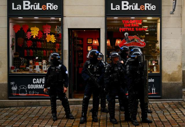 French Police officers in riot gear patrol during a demonstration in favor of purchasing power, the protection of public services, and fiscal and social justice, in Nantes, western France on October 24, 2026 as part of a nationwide call for mobilisation bringing together former members of the Yellow Vest movement, labor unions, high school and university students. Protests by high school students over learning conditions sparked a movement that has since spread nationwide, fuelled by broader anger over the rising cost of living. About 70,000 security personnel will be deployed on October 24, 2026, Interior Minister said at a news conference, warning that calls for violence and looting were circulating on social media. (Photo by Guillaume Saligot / AFP)