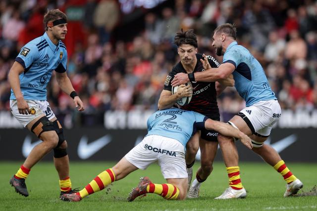 Toulouse's Belgian full-back Matias Remue (2R) is tackled during the French Top14 rugby union match between Stade Toulousain and USA Perpignan at the Ernest Wallon Stadium in Toulouse, southwestern France, on October 24, 2026. (Photo by Valentine CHAPUIS / AFP)