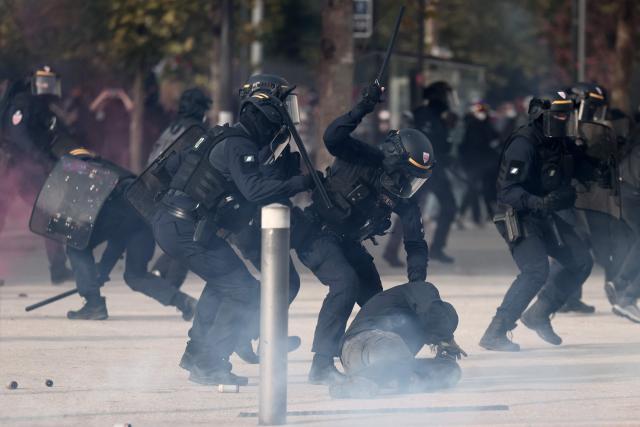 TOPSHOT - A French Republican Security Corps (CRS - Compagnies Republicaines de Securite) officer beats a protester with a baton during a demonstration in favor of purchasing power, the protection of public services, and fiscal and social justice, in Marseille, southeastern France on October 24, 2026 as part of a nationwide call for mobilisation bringing together former members of the Yellow Vest movement, labor unions, high school and university students. Protests by high school students over learning conditions sparked a movement that has since spread nationwide, fuelled by broader anger over the rising cost of living. About 70,000 security personnel will be deployed on October 24, 2026, Interior Minister said at a news conference, warning that calls for violence and looting were circulating on social media. (Photo by Thibaud MORITZ / AFP)