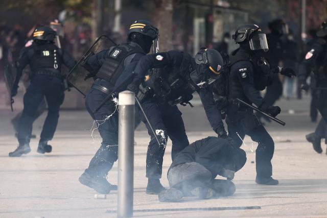A French Republican Security Corps (CRS - Compagnies Republicaines de Securite) officer holds a protester during a demonstration in favor of purchasing power, the protection of public services, and fiscal and social justice, in Marseille, southeastern France on October 24, 2026 as part of a nationwide call for mobilisation bringing together former members of the Yellow Vest movement, labor unions, high school and university students. Protests by high school students over learning conditions sparked a movement that has since spread nationwide, fuelled by broader anger over the rising cost of living. About 70,000 security personnel will be deployed on October 24, 2026, Interior Minister said at a news conference, warning that calls for violence and looting were circulating on social media. (Photo by Thibaud MORITZ / AFP)
