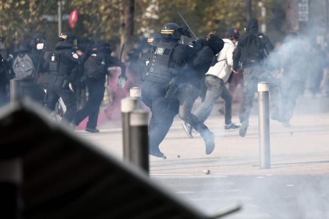 A French Republican Security Corps (CRS - Compagnies Republicaines de Securite) officer hits and pushes a protester during a demonstration in favor of purchasing power, the protection of public services, and fiscal and social justice, in Marseille, southeastern France on October 24, 2026 as part of a nationwide call for mobilisation bringing together former members of the Yellow Vest movement, labor unions, high school and university students. Protests by high school students over learning conditions sparked a movement that has since spread nationwide, fuelled by broader anger over the rising cost of living. About 70,000 security personnel will be deployed on October 24, 2026, Interior Minister said at a news conference, warning that calls for violence and looting were circulating on social media. (Photo by Thibaud MORITZ / AFP)