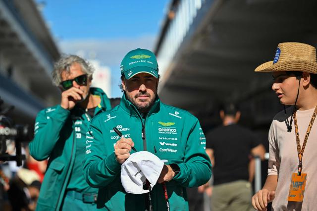 Aston Martin's Spanish driver Fernando Alonso signs an autograph for a fan as he arrives in the paddock ahead of the final practice session for the United States Formula One Grand Prix at the Circuit of the Americas in Austin, Texas, on October 24, 2026. (Photo by ANGELA WEISS / AFP)