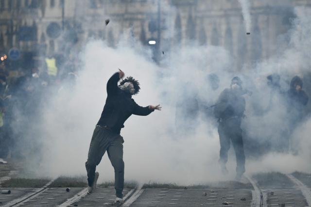 Protesters clash with police near Place de la Bourse, in a protest ban zone, as part of a demonstration in favor of purchasing power, the protection of public services, and fiscal and social justice, in Bordeaux, western France on October 24, 2026 as part of a nationwide call for mobilisation bringing together former members of the Yellow Vest movement, labor unions, high school and university students. Protests by high school students over learning conditions sparked a movement that has since spread nationwide, fuelled by broader anger over the rising cost of living. About 70,000 security personnel will be deployed on October 24, 2026, Interior Minister said at a news conference, warning that calls for violence and looting were circulating on social media. (Photo by Philippe LOPEZ / AFP)