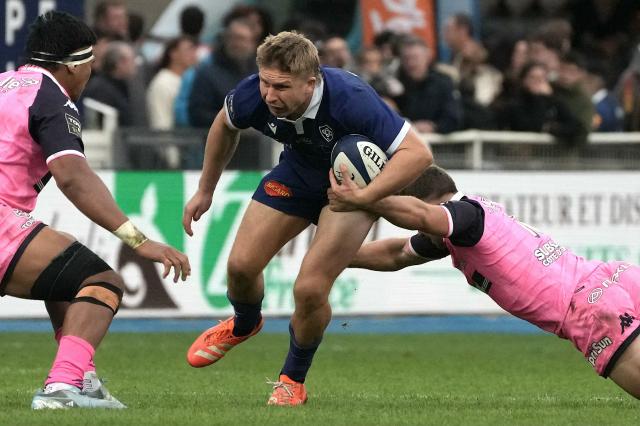 Castres Olympique’s New Zealand outside centre Elias Jack Goodhue (C) is tackled during the French Top14 rugby union match between Castres Olympique and Stade Franзais Paris at Stade Pierre-Fabre in Castres, southwestern France on October 24, 2026. (Photo by Idriss Bigou-Gilles / AFP)