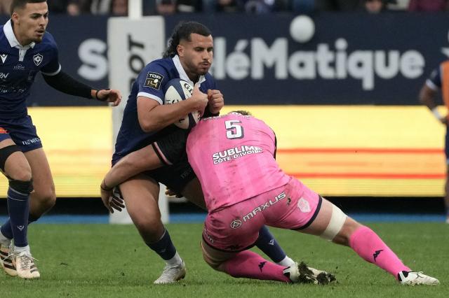 Castres Olympique’s French fly-half Louis Le Brun (C) is tackled By Stade Francais Paris’ French lock  Fabrice Metz (R) during the French Top14 rugby union match between Castres Olympique and Stade Franзais Paris at Stade Pierre-Fabre in Castres, southwestern France on October 24, 2026. (Photo by Idriss Bigou-Gilles / AFP)