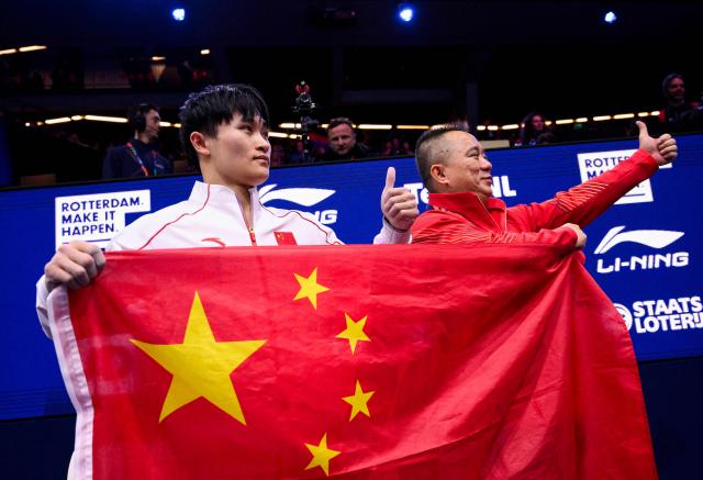 China's Xingyu Lan celebrates with his coach after winning the Men's Rings Final during the 54th FIG Artistic Gymnastics World Championships, in Rotterdam, southern Netherlands, on October 24, 2026. (Photo by JOHN THYS / AFP)