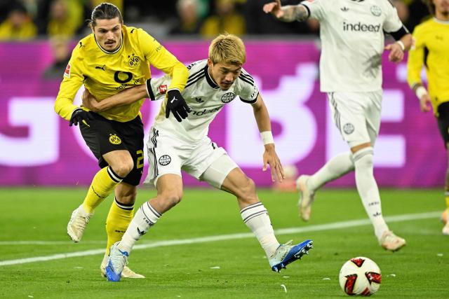 Dortmund's Austrian midfielder #20 Marcel Sabitzer and Frankfurt's Japanese forward #20 Ritsu Doan vie for the ball during the German first division Bundesliga football match between BVB Borussia Dortmund and Eintracht Frankfurt in Dortmund, western Germany on October 24, 2026. (Photo by INA FASSBENDER / AFP) / DFL REGULATIONS PROHIBIT ANY USE OF PHOTOGRAPHS AS IMAGE SEQUENCES AND/OR QUASI-VIDEO