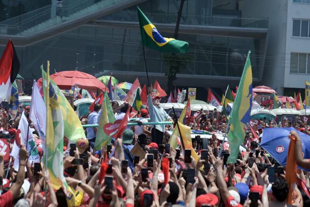 Brazil's President and presidential candidate Luiz Inacio Lula da Silva (C) of the Workers' Party (PT) waves a Brazilian flag during a rally on Copacabana beach in Rio de Janeiro, Brazil, on October 24, 2026, ahead of the presidential election runoff. (Photo by TERCIO TEIXEIRA / AFP)