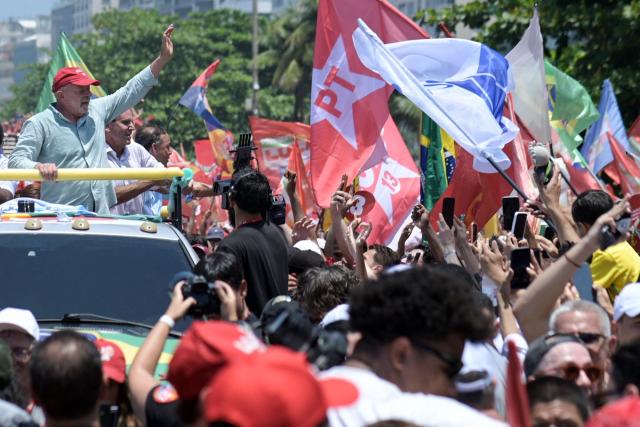 Brazil's President and presidential candidate Luiz Inacio Lula da Silva (L) of the Workers' Party (PT) waves to supporters during a rally on Copacabana beach in Rio de Janeiro, Brazil, on October 24, 2026, ahead of the presidential election runoff. (Photo by TERCIO TEIXEIRA / AFP)