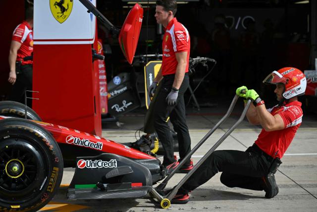 Ferrari technicians work on the car of Ferrari's Monegasque driver Charles Leclerc ahead of the final practice session for the United States Formula One Grand Prix at the Circuit of the Americas in Austin, Texas, on October 24, 2026. (Photo by ANGELA WEISS / AFP)