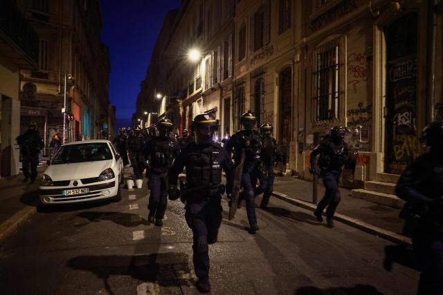 French Republican Security Corps (CRS - Compagnies Republicaines de Securite) police officers run down a street during a demonstration in favor of purchasing power, the protection of public services, and fiscal and social justice, in Marseille, southeastern France on October 24, 2026 as part of a nationwide call for mobilisation bringing together former members of the Yellow Vest movement, labor unions, high school and university students. Protests by high school students over learning conditions sparked a movement that has since spread nationwide, fuelled by broader anger over the rising cost of living. About 70,000 security personnel will be deployed on October 24, 2026, Interior Minister said at a news conference, warning that calls for violence and looting were circulating on social media. (Photo by Thibaud MORITZ / AFP)