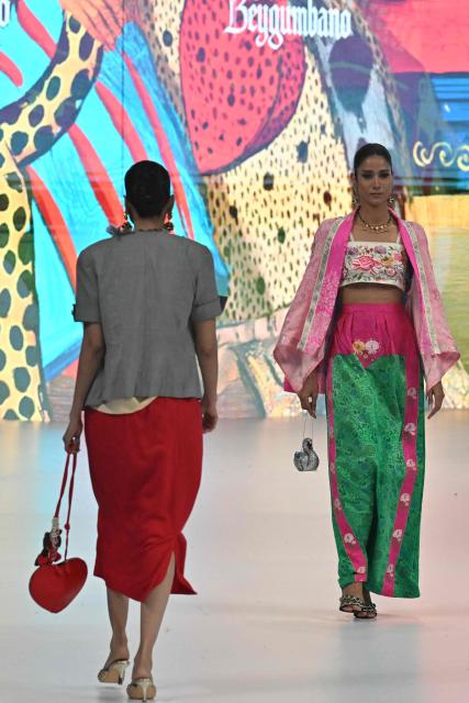 Models present creations by fashion designer Beygum Bano during LAAM Fashion Week in Lahore on October 24, 2026. (Photo by Arif ALI / AFP)