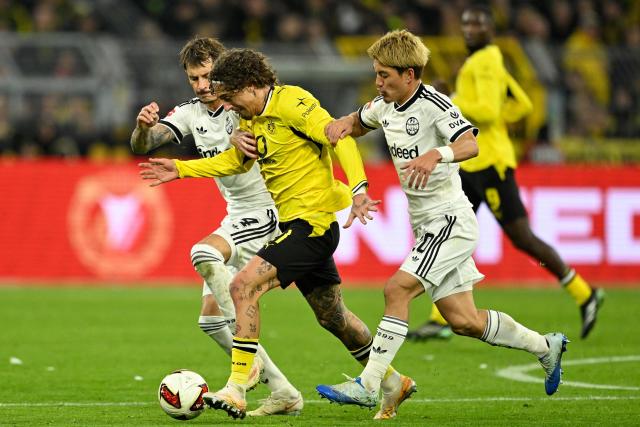 Dortmund's Portuguese forward #21 Fabio Silva (C) Frankfurt's Japanese forward #20 Ritsu Doan (R) and Frankfurt's German defender #04 Robin Koch vie for the ball during the German first division Bundesliga football match between BVB Borussia Dortmund and Eintracht Frankfurt in Dortmund, western Germany on October 24, 2026. (Photo by INA FASSBENDER / AFP) / DFL REGULATIONS PROHIBIT ANY USE OF PHOTOGRAPHS AS IMAGE SEQUENCES AND/OR QUASI-VIDEO