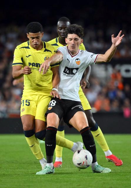Villarreal's Uruguayan defender #15 Santiago Mourino and Valencia's Spanish midfielder #18 Pepelu fight for the ball during the Spanish league football match between Valencia CF and Villarreal CF at Mestalla Stadium in Valencia on October 24, 2026. (Photo by JOSE JORDAN / AFP)