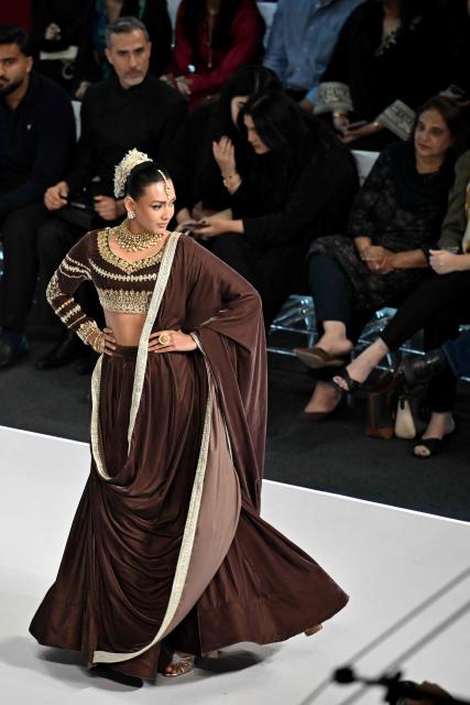 A model presents a creation by fashion designer Izna Hamza during the a LAAM Fashion Week in Lahore on October 24, 2026. (Photo by Arif ALI / AFP)