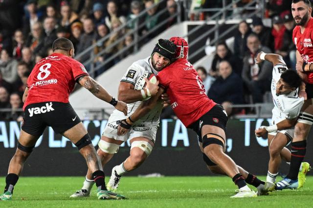 Pau's Georgian flanker Beka Gorgadze (CL) is tackled as he runs with the ball during the French Top14 rugby union match between RC Toulon and Section Paloise (Pau) at the Stade Mayol in Toulon, southeastern France, on October 24, 2026. (Photo by Justine Meddah / AFP)