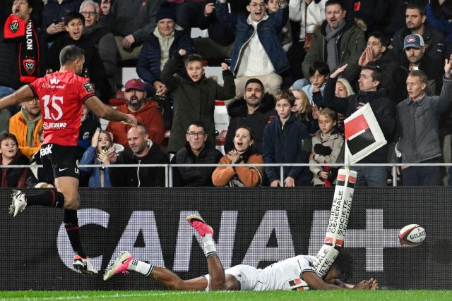 Pau's French wing Theo Attissogbe (R) knocks the ball into touch as he fails to score a try during the French Top14 rugby union match between RC Toulon and Section Paloise (Pau) at the Stade Mayol in Toulon, southeastern France, on October 24, 2026. (Photo by Justine Meddah / AFP)