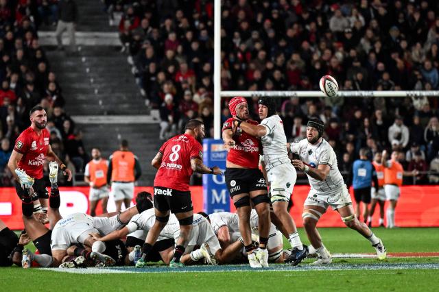 Toulon’s English flanker Zach Mercer (C) spills the ball as he is tackled during the French Top14 rugby union match between RC Toulon and Section Paloise (Pau) at the Stade Mayol in Toulon, southeastern France, on October 24, 2026. (Photo by Justine Meddah / AFP)