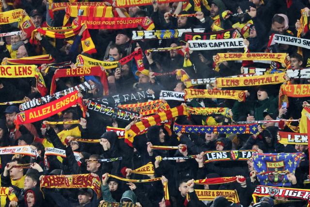 Lens supporters wave their scarves during the French L1 football match between RC Lens and Paris FC at the Stade Bollaert-Delelis in Lens, northern France, on October 24, 2026. (Photo by Francois LO PRESTI / AFP)